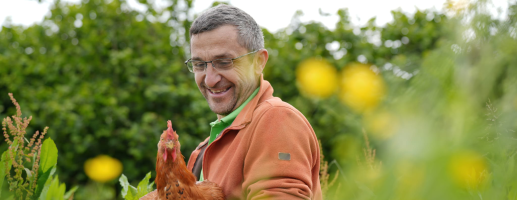 Philippe Belche, polyculteur-éleveur à la Ferme de Habaru, avec un de ses poulets de chair
